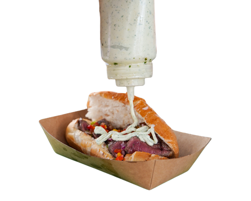 Garlic mayo being poured onto Brazilian roll